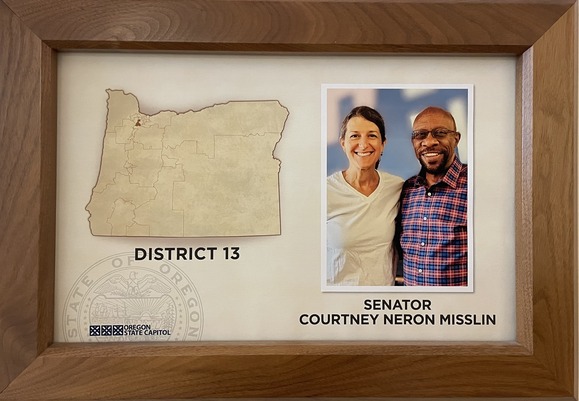 Sen. Neron Misslin has used a photo of her and the late Sen. Arron Woods together to honor him on her Senate office plaque