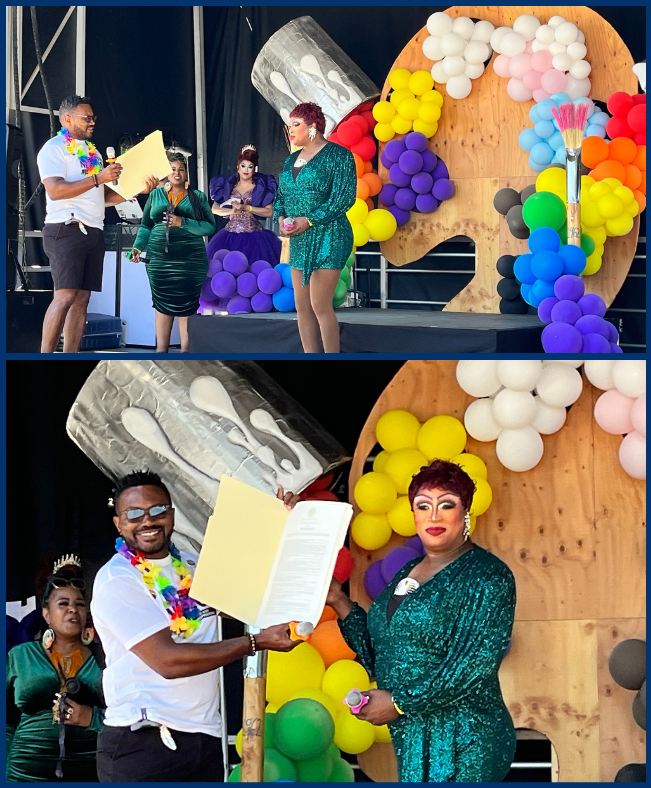 rep nelson on stage giving copy of resolution to another drag queen, courtney