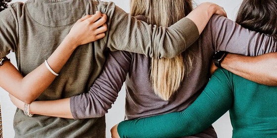 Image of three people supporting one another