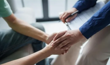 Image of a person holding another person's hand in support 