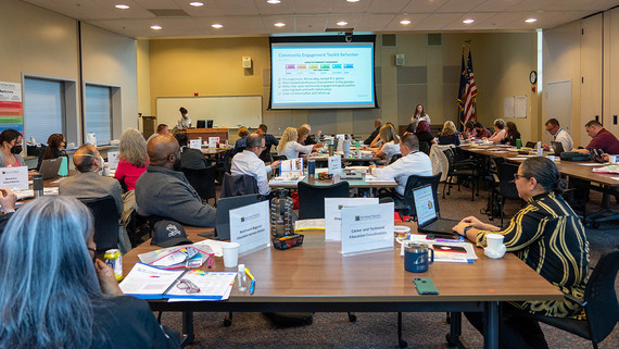 people attend an in-person conference in a large conference room