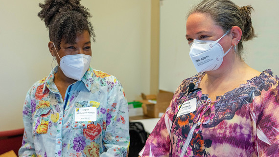 Renae Iversen and Inger McDowell-Hartye pose for a photo in a conference room