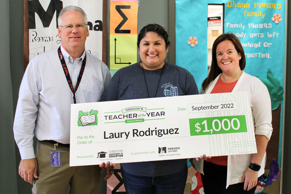 Laury Rodriguez holds an oversized check