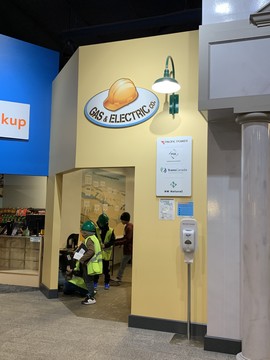 Gas & Electric store front with students dressed in construction gear