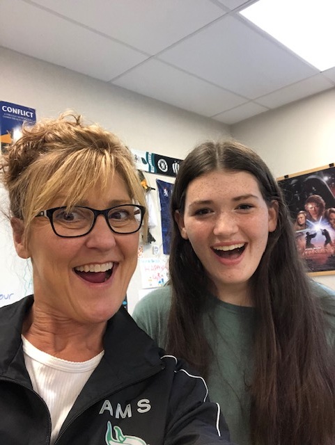 A principal poses for a selfie with a high school student