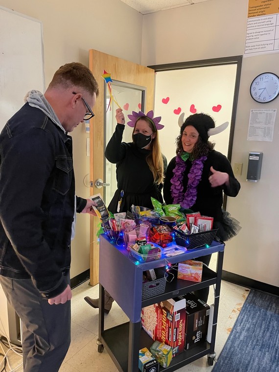 Tim Prosser selects a snack while Bethany Bowers and Cara Olson Sawyer pose for a photo