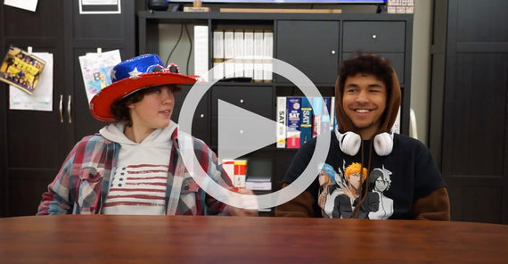 two high school students sit next to each each other at a table