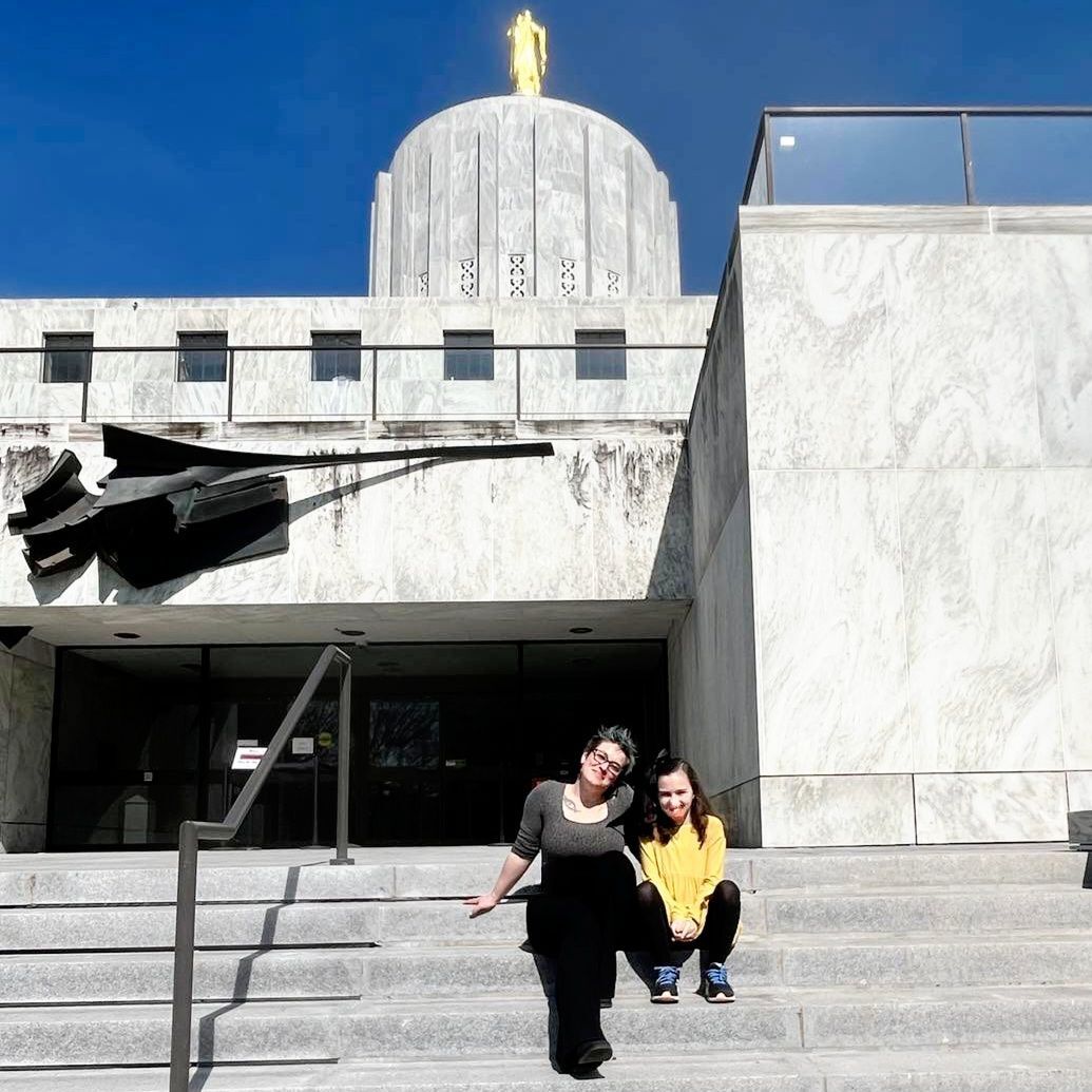 Carissa and Jemma sit on the steps of the Oregon State Capitol building