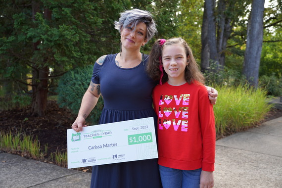 Carissa Martos poses with an oversized check with student Jemma Bosotina 