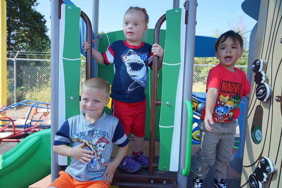 three preschoolers on a playground