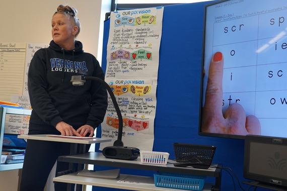 a teacher points to the letter o