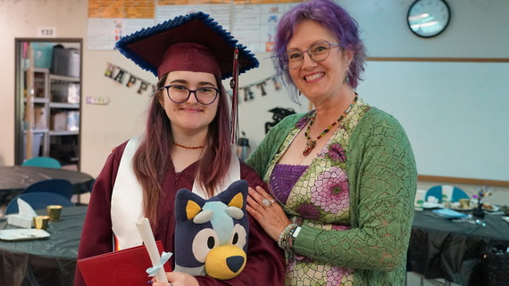 a student in a graduation gown with their mom