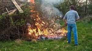 Photo of man stoking a burn pile