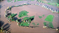 Spring flooding in Oregon, island of green surrounded by brown muddy water