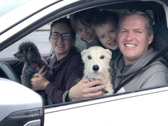 Father, mother and two sons in a Subaru with their two dogs
