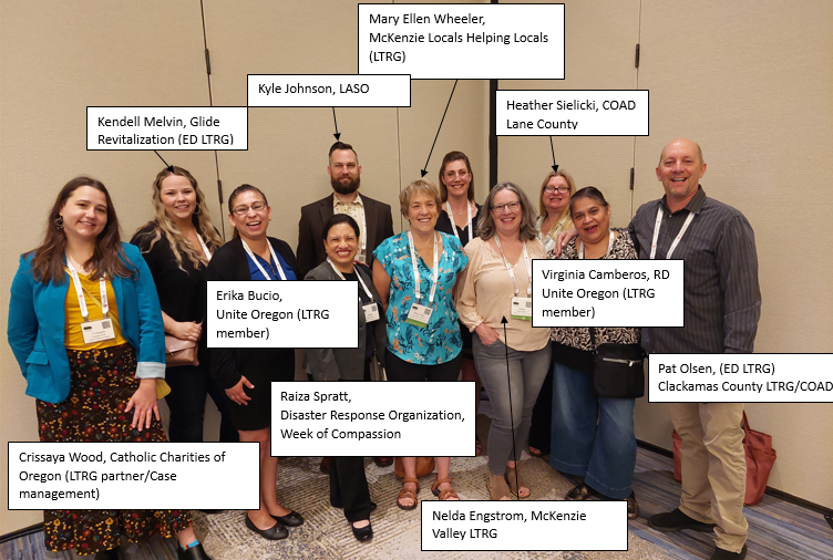 11 smiling men and women pose for a photo at a conference