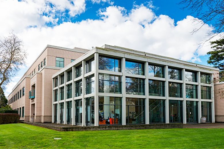 The exterior of the Oregon Department of State Lands building is shown, featuring an area of the tan-brick building that's all windows.