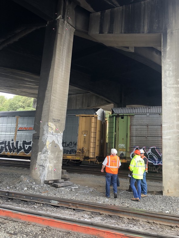 Engineers stand next to column