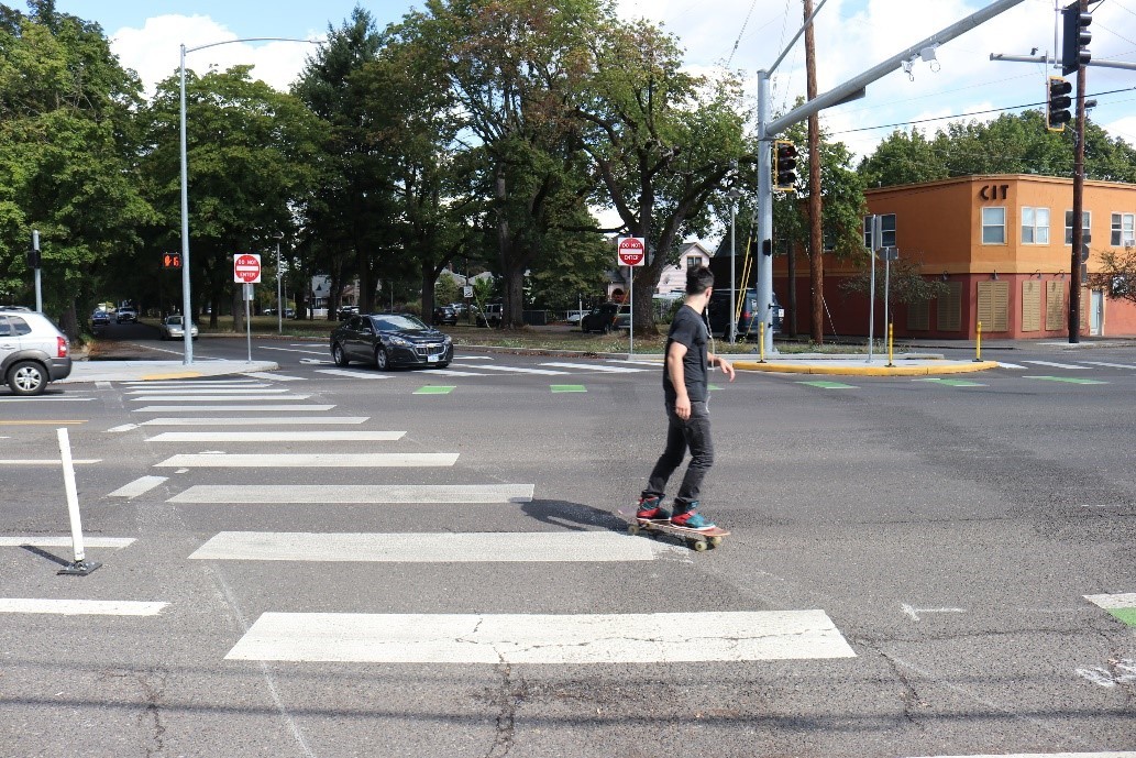 Skateboarder using a new crosswalk on Foster Road