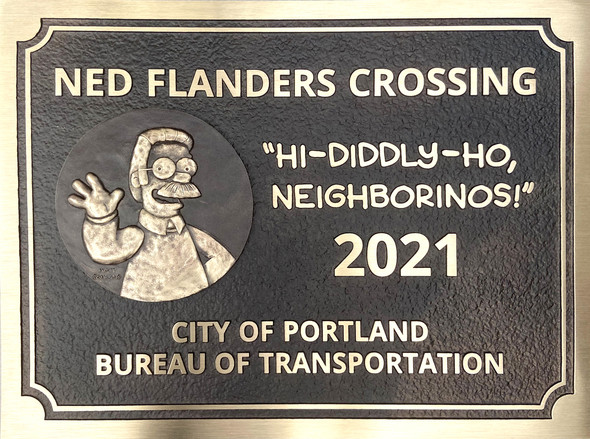 The plaque is cast in bronze with Ned Flanders waving next to his catchphrase “Hi-Diddly-Ho, neighborinos!”; with Matt Groening’s signature. 