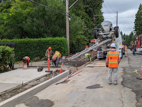 Construction crew pours concrete for pathway on Southwest Capitol Highway