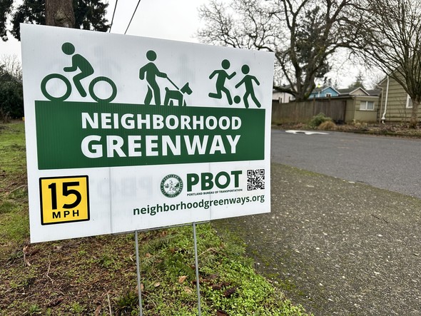 Neighborhood Greenway sign in green and white promoting slow streets