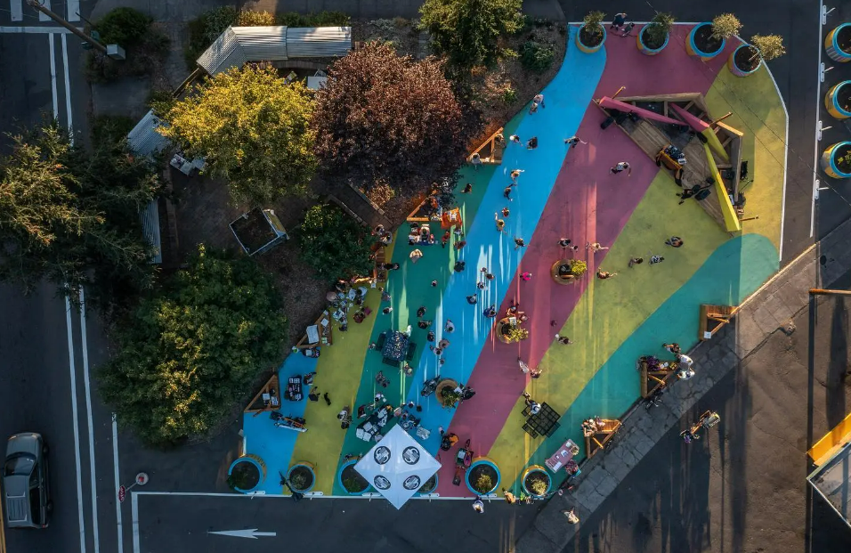 An Aerial View of Arleta Triangle Square with many people gathering below.