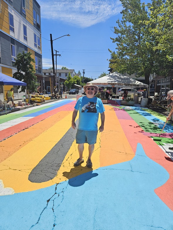 PBOT Staffer, Greg Raisman, stands in front of a freshly painted plaza at the Concordia Commons.