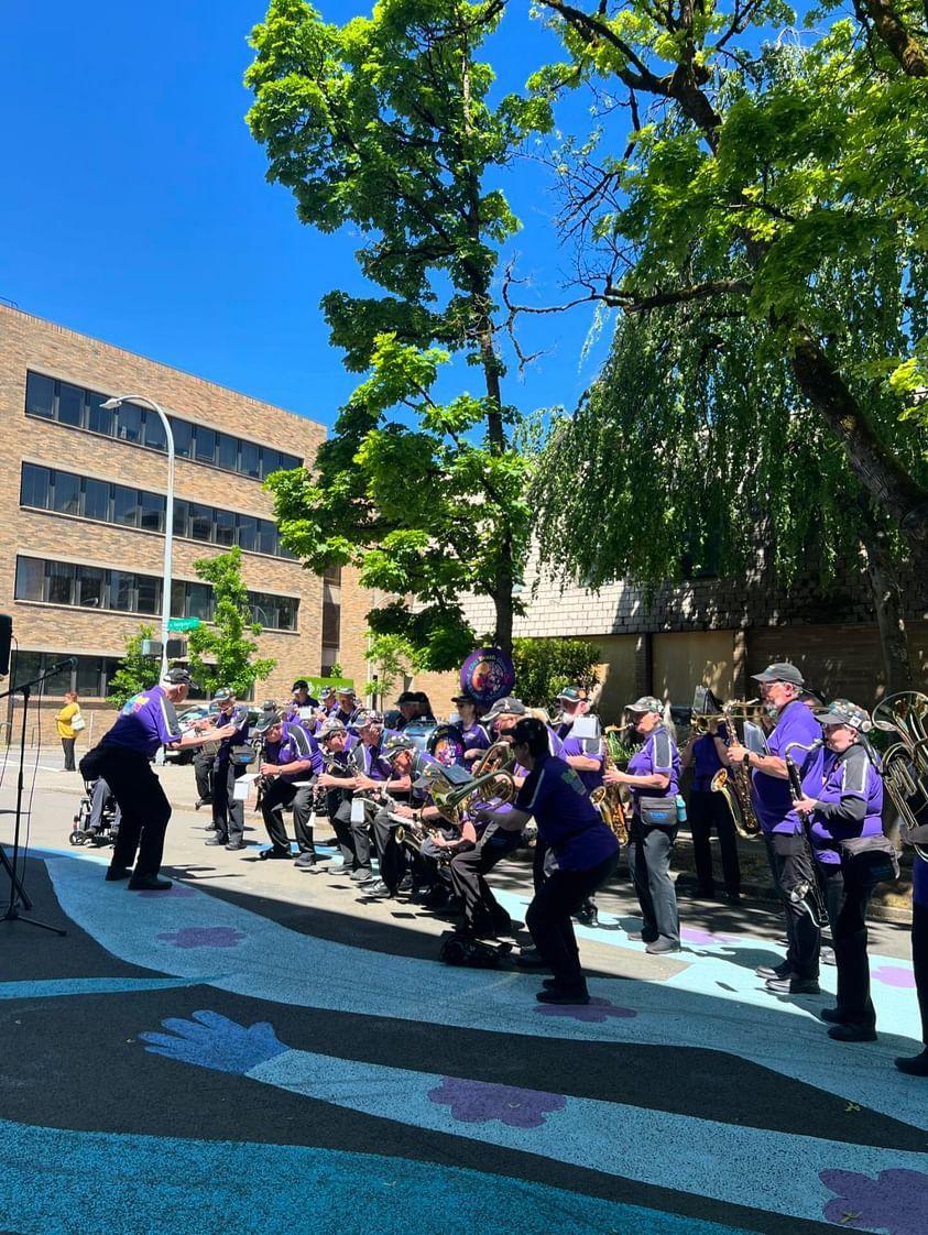 A big band of seniors dressed in purple play at Montgomery Plaza
