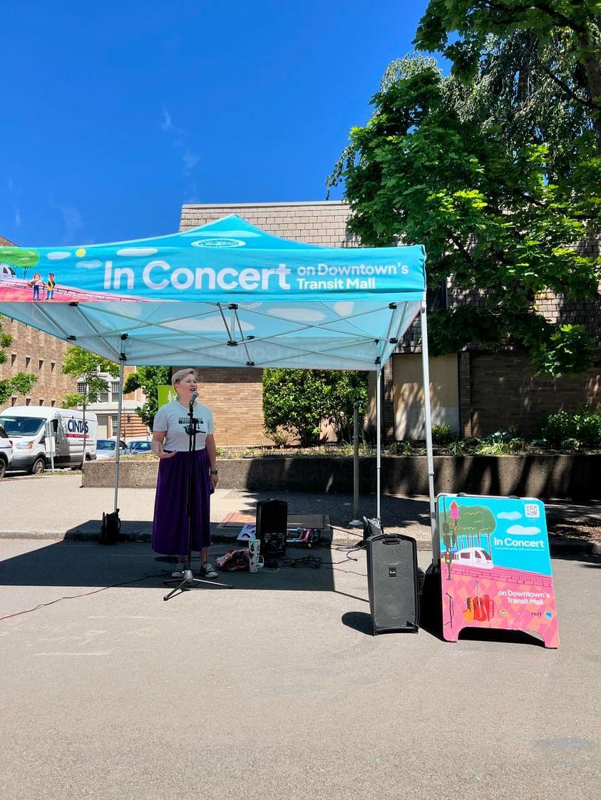 An opera singer sings under a popup tent at Montgomery Plaza