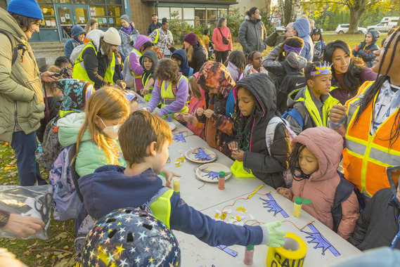 Dozens of children surround a table with arts and crafts activities before the start of the school day.
