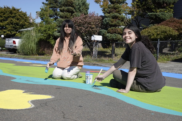 Two Parkrose high school students smile while painting the street mural.