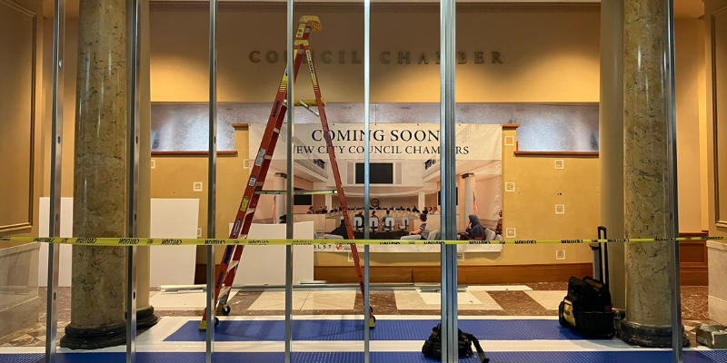 City Hall Chambers' wall with caution tape in front of it.