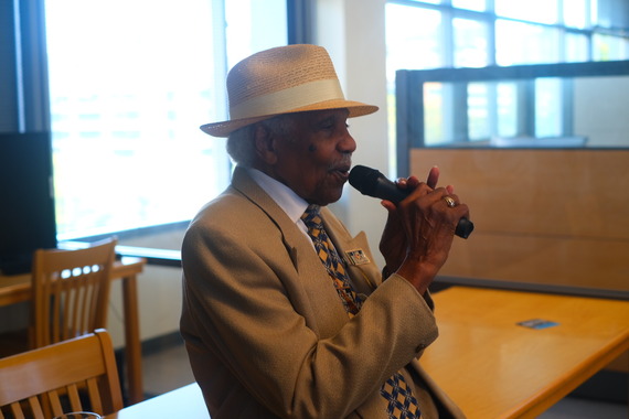 A man in a hat speaks into a microphone at the City Archives Open House 2024