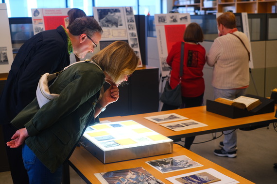 Community members inspecting photographs at the City Archives