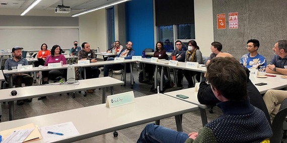 Committee members sitting around a rectangular table discussing issues