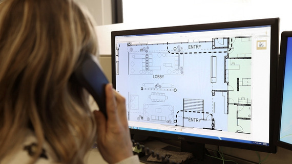 Customer service representative on phone looking at computer screen with floor plans