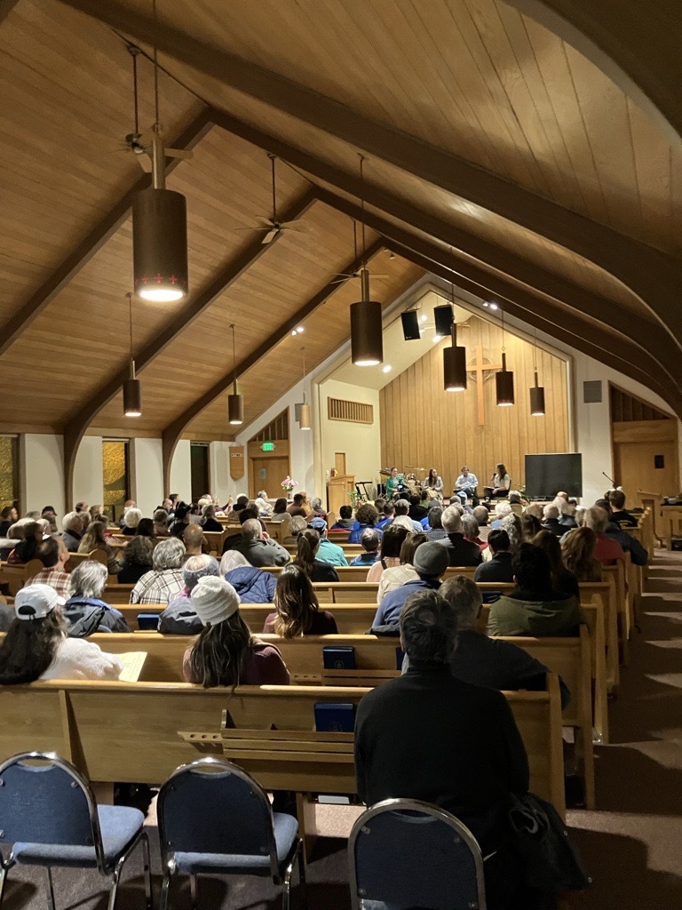 Picture from the back of Calvary Presbyterian Church with full pews and councilors at the front. 