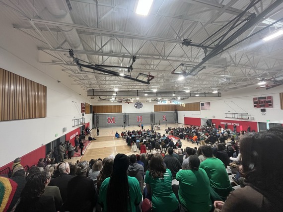 Photo of McDaniel HS gym packed with attendees and US Sen Merkley up front