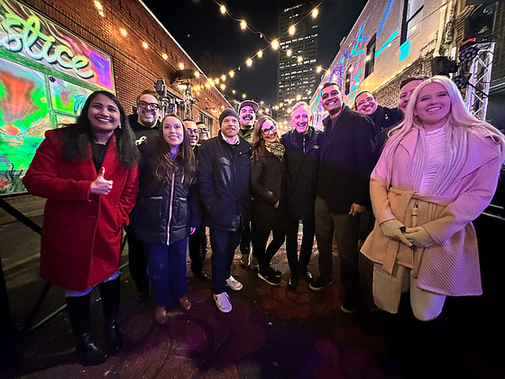 Mayor Wilson, City Councilors, other city leaders, and members of Ankeny Alley Association pose in the newly lit Ankeny Alley