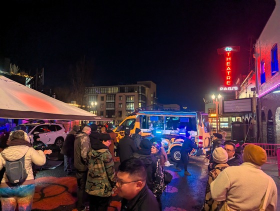 A crowd dances in front of a lit up DJ bus at Ankeny Alley.