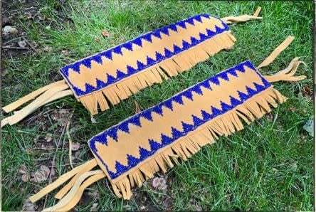 Two strands of vibrant beadwork lie on a stretch of grass.