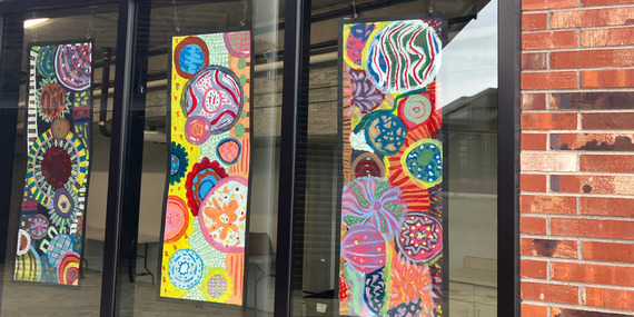 Student artwork is displayed in storefront windows