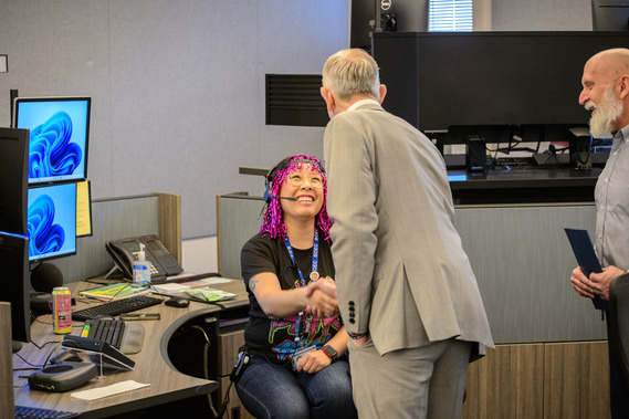 A 911 call taker smiles as she shakes hands with Mayor Keith Wilson