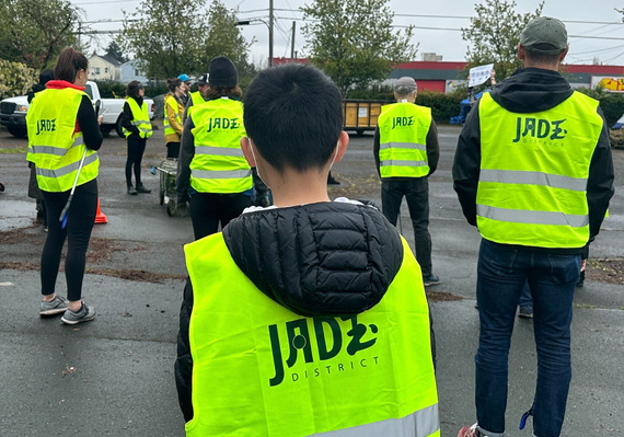 Volunteers in yellow safety vests that say "Jade District"