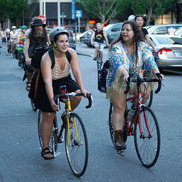 Two people ride bicycles in a group of riders along a Portland street (bike, bikes)