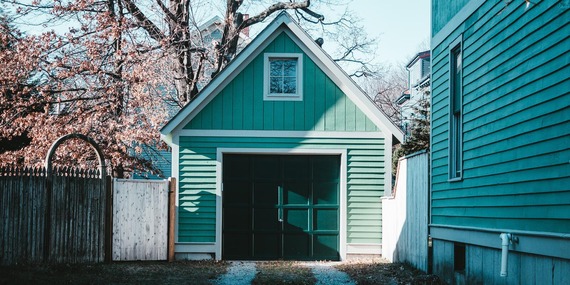 Detached garage with second-floor window and surrounded by fences on both sides