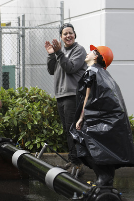 A Water Bureau employee applauds the effort of a middle school student.