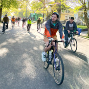 A bicycle rider leads dozens of other bicyclists down a Portland neighborhood street during a bike bus event.
