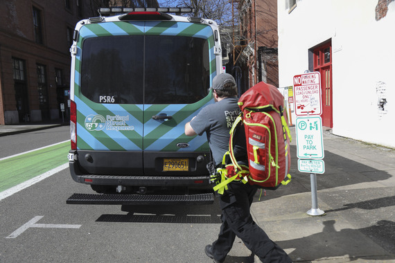 Portland Street Response vehicle and staffer carrying a first aid backpack in downtown